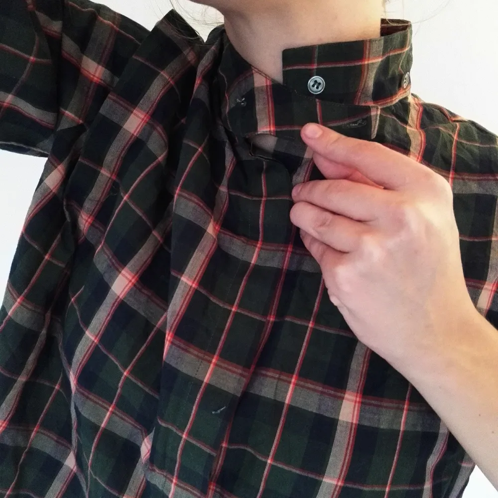 Snygg rutig bomullsskjorta! Funkar båda som knyttopp och vanlig skjorta. Bild två visar halsknäppningen och sömmen vid axlarna, bild två visar också bäst på färgerna. En av knapparna saknas, därför det låga priset! Jag tycker inte det gör något dock, den funkar bra att knäppa ändå :). Skjortor.