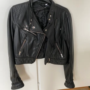 Skinnjacka 36 - Skinnjacka från H&M strl 36. Använt men fint skick. Kan fraktas om köparen betalar frakten. Hund finns i hemmet! 