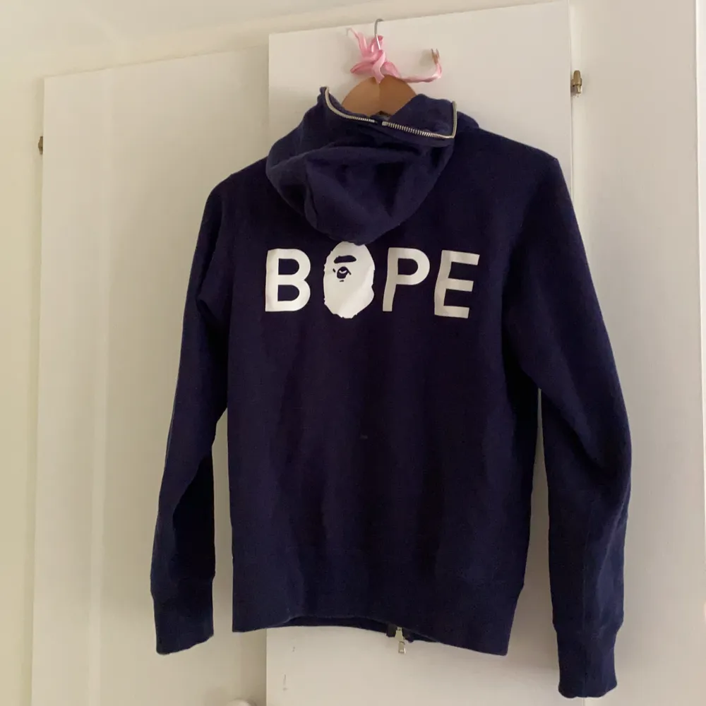 Supersnygg hoodie från BAPE, endast använd en gång. Mörkblå med tryck på ryggen och har strass stenar på framsidan. Passar xs-s. PRIS KAN DISKUTERAS VID SNABB AFFÄR. Hoodies.