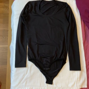 Svart body i satin, FRAKT INGÅR  - Oanvänd body i satin, otroligt skön material! 