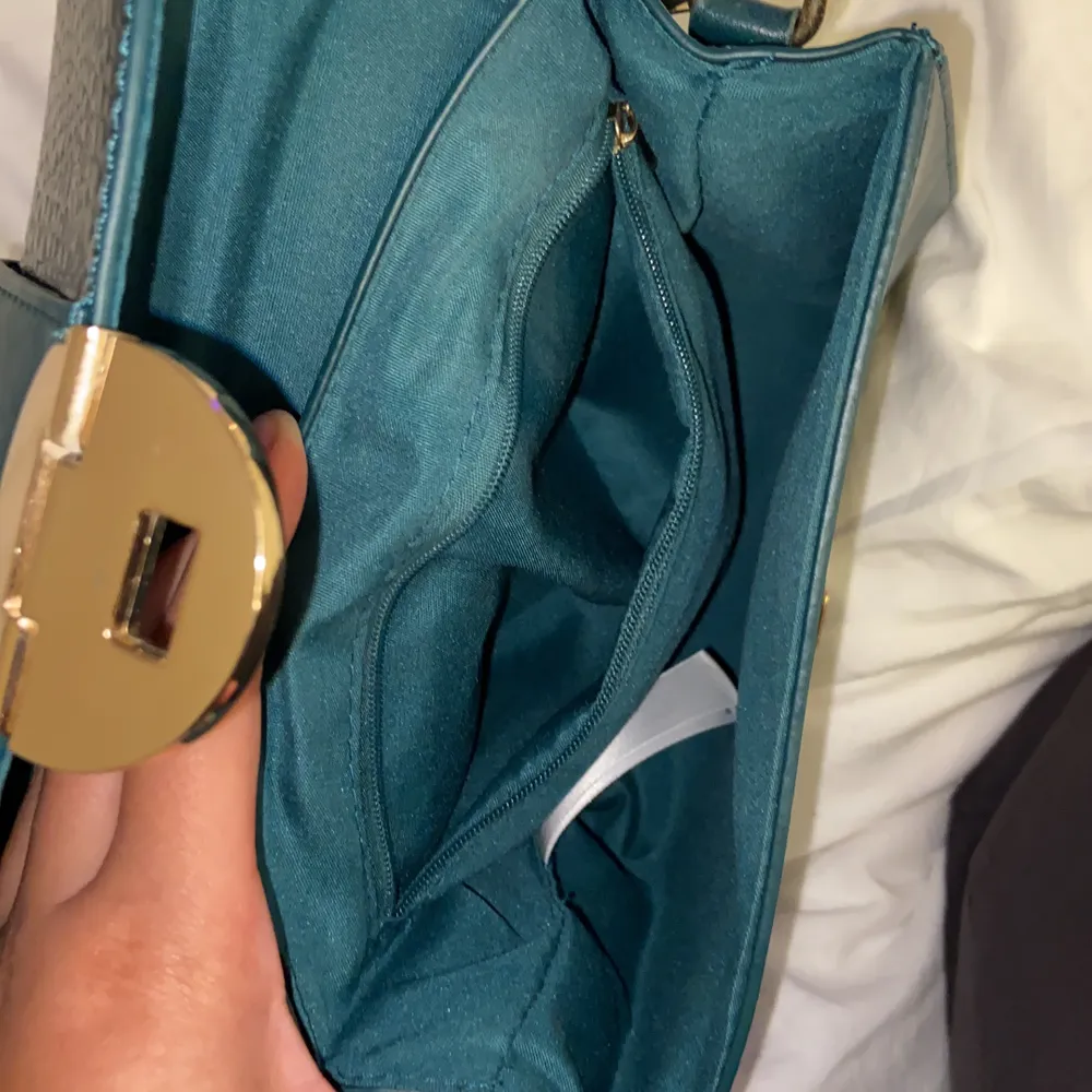 Säljer min knappt använda gröna väska med snygga guld detaljer och snygg modell, bandet är långt och justerbart. Väskor.