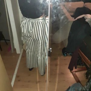 Ammos fashion byxor köpta i Grekland. - Super sköna byxor med svarta ränder och ett band som knyts runt midjan. Dem är vida ner till men sitter jätte bra vid bakdelen. Skulle säga det är storleken M men kan absolut passa både en S och en L då de är väldigt stretchiga.
