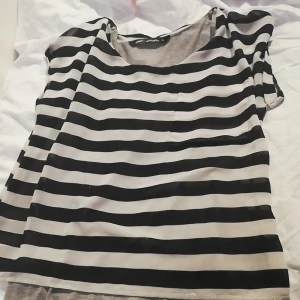 Blus  - En randig blus med ett grått slags linne under. Lätt och ta av ifall man vill. 