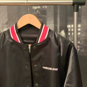 Calvin Klein jacka - Äkta jacka från märket Calvin Klein i skinnimitation. Tufft och snyggt på samma gång! 