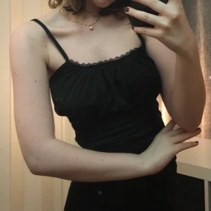 Svart ruffle topp - Supergulligt linne i färgen svart! Knappt använd och i bra skick. Inte typiskt t-shirt tyg, lite mer polyester. Jag är storlek xs/s och denna sitter bra på mig (: 30kr +frakt. Pris kan diskuteras !