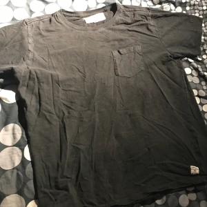 Svart T-shirt - En fin svart t-shirt från Garcia Jeans med en fika på vänstra sidan av bröstet👕 Den har varit använd ofta och är lite sliten,  men den ser nästan precis likadan ut som ny!🤩🙌🏼  📤Köparen står för frakt, 22kr🚚