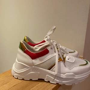 Chunky sneakers - Vita sneakers i strl 39. Chunky modell med färgglada detaljer! Använda endast en gång så i mycket bra skick. Märke är okänt, kan vara asos eller liknande.