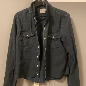 Halv kroppad svart jeans skjorta  - Säljer denna halv kroppade svarta jeans skjortan, används snyggt både öppen som stängd. 