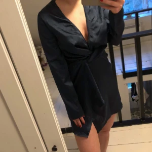 Klänning i silke storlek 36 - Jättefin klänning i silke! Stängs med en dragkedja i sidan. Urringad och fin omlott-detalj under brösten. Mörkblå ✨ sparsamt använd!