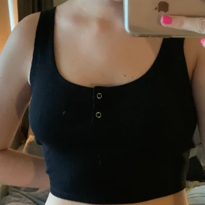 Bik Bok svart linne - Säljer min svarta topp med knappar där fram från Bik Bok då den var lite för stor för mig så har aldrig andvänt den. Storlek M men passar även en S. Köpt för 200kr så säljer för 100kr.