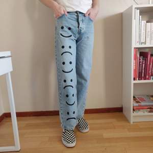 Ett par utsvängda jeans med handmålad tryck. Högmidjade, storlek 27. Passar längdmässigt till dig som är runt 175cm lång. ♻️ Fraktkostnad på 63kr tillkommer. ✨