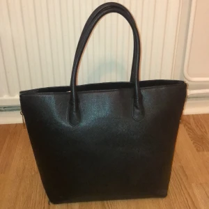 Väska - 💕Säljer en svart väska som bara står i garderob och inte blir anvönd. Den är fräsh och har två dragkedjor som man kan dra ner om man vill få den större. 45 cm bred och 35 cm hög. Hämtas i hagsätra men kan oxå mötas i T-centralen. 