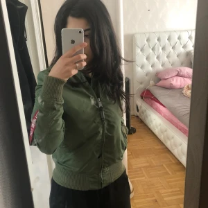 Alpha bomberjacka grön - Tänkte sälja min gröna alphajacka som är i XS då den bara ligger i garderoben. Sitter ganska fint, men inte min stil längre. Den är nästan i nyskick då jag knappt använt den. Skulle nog säga att jag använt den sparsamt max 6-7 gånger. Buda från 700 kr. Nypris ca 2100 kr. (Smutsig spegel, inga fläckar på jackan)