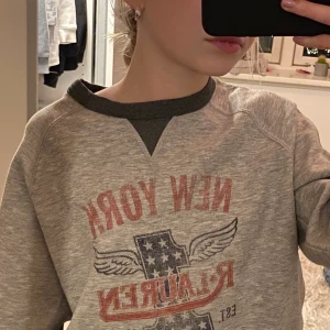 Snygg trendig tjocktröja med tryck  - Säljer en snygg tjocktröja ifrån Ralph Lauren, säljer pga att den kommer inte till användning. Tröjan är köpt för några år sedan men är knappt använd. Tröjan sitter bra på mig som är en XS. Köp direkt för 200 eller buda. Köparen står för frakt. 