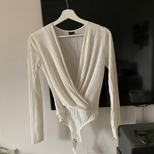 Body med v-ringning - Tyget är tunt! Från Gina tricot