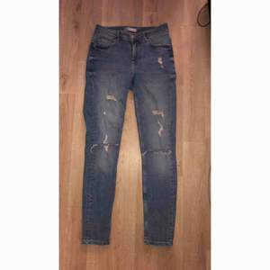 Jeans med slitningar och hål på knäna från Gina tricot Storlek 27  Använda 1 gång 