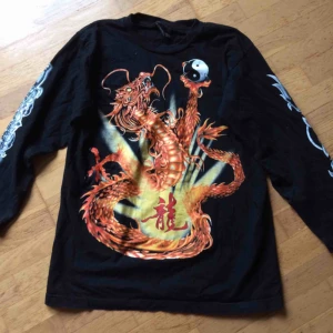  - Tröja med kinesisk drake print framtill o bak. Trycket är i färg på framsidan och svart/vitt på baksidan. Även print på armarna. Storlek M. Använd men i fint skick. Priset är inkl vanlig frakt :)