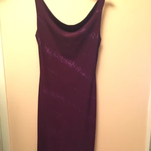  - Vacker mörklila klänning. Längd: 101 cm 
Använt 1 gång till nyår