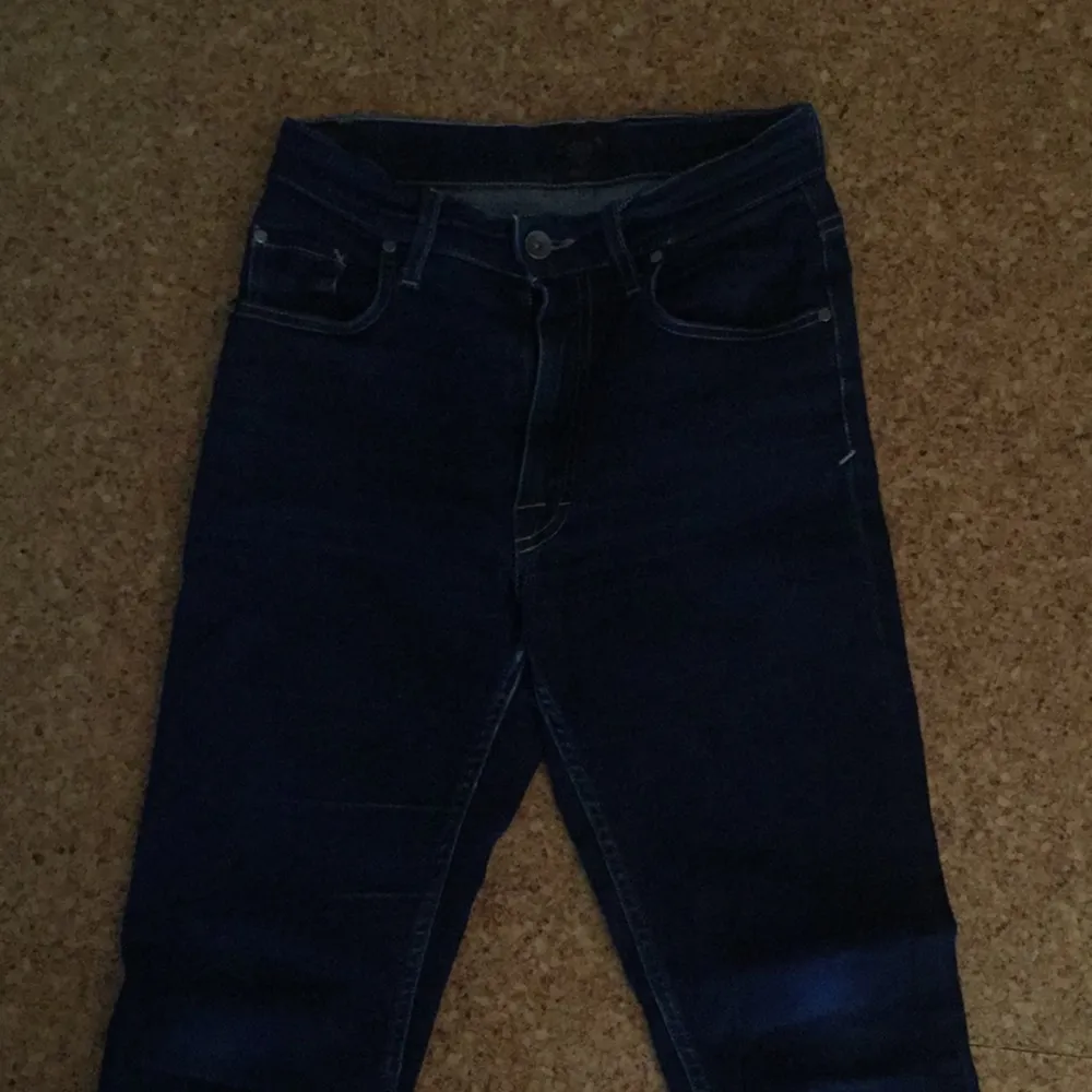 Mörkblå Tiger Jeans med högmidja. Något slitna samt uppsydda några cm.. Jeans & Byxor.