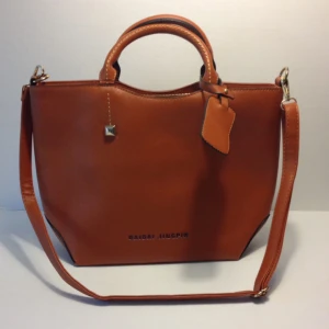  - Läcker handväska i präglat PU-skinn. Praktisk axelrem och massa bra fickor. Fina gulddetaljer. Helt ny.   Finns för hämtning i centrala Stockholm, men kan även skickas med post för 49:-