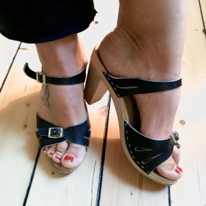  - "Svenska trätofflor" Svarta skinn trätofflor med klack, guldknäppen och öppen häl. Riktigt snygga och sköna, dock köpte jag dom lite hastigt och är lite för stora för mig. Hör av dig om du vill veta mer:) 