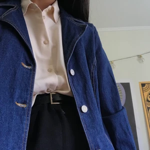 Lång jeansjacka  - Thriftad lång jeansjacka i 80-talsmodell. Märkt som storlek 40, men passar mig som är en storlek 36. Materialet är 98% bomull och 4% elastan. I gott skick! Har endast använd den 1 gång :)