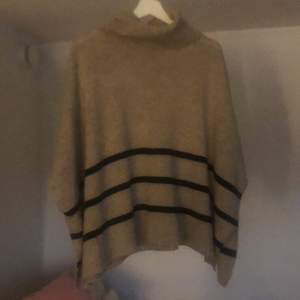 En beige stickad väst/poncho med polokrage