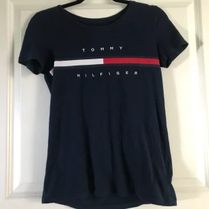 Tshirt - Trendig marinblå Tommy Hiftiger t-shirt med logga på bröstet. Storlek XXS men jag skulle säga att den motsvarar en S. 