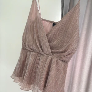  - Champagnefärgad partytopp från Gina tricot i storlek M. Sitter fin på kroppen och passar storlek S till L.