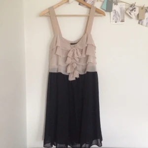  - Fin svart festklänning med beige volanger och rosetter upptill 🎀 Står ej för frakt