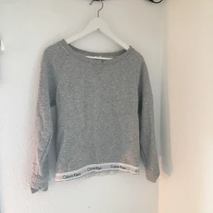  - Tjocktröja från Calvin Klein med märket vid botten både fram och bak.