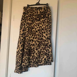  - Helt oanvänd leopardkjol i tunt tyg. Lite volangig och snedskuren nedtill i modellen, blixtlås i sidan.  Frakt tillkommer!