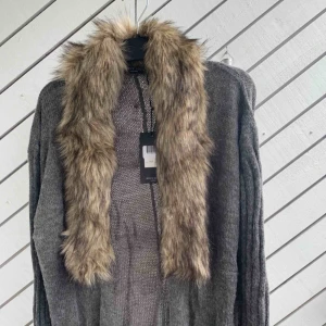  - En fin stickad lång Cardigan med päls runt om, är avtagbar ! Helt ny me etikett på!  Köparen står för frakten!