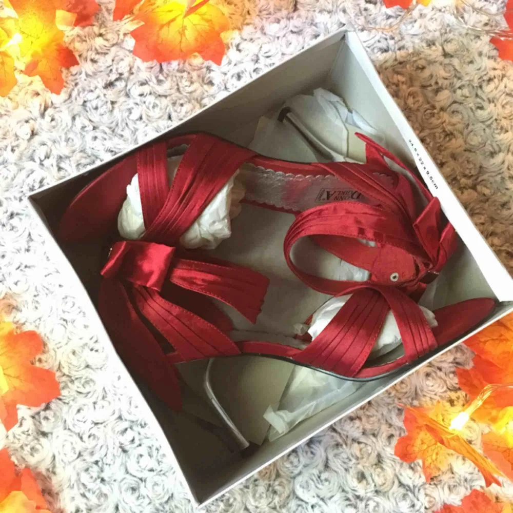 Röda sandaletter / pumps i satin, med söt rosett baktill och snygg silverfärgad klack. Endast använda ett fåtal gånger, sula och klack i perfekt skick. Stl.40. Skor.