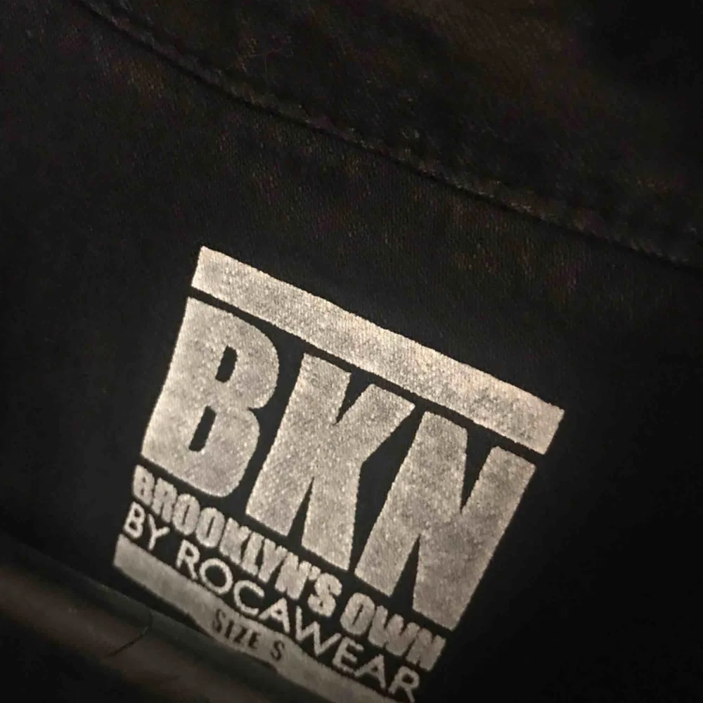 Svart jeansskjorta med vita detaljer i märket BKN Brooklyn’s Own by Rocawear. Storlek S men är stor i storleken. Funkar till både killar och tjejer. Endast använd 2 gånger - som ny!! . Skjortor.