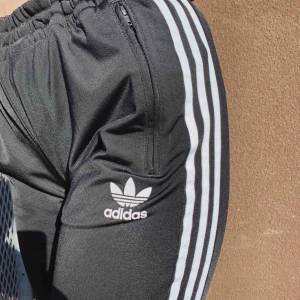  - Adidasmjukisbyxa med ”bootcut”. 
