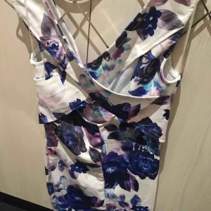  - Otroligt fin klänning, helt oanvänd med prislapp kvar! Tight modell, jättefint mönster och färger med snygga detaljer såsom korsad i ryggen. Perfekt till finare tillställningar, ec bröllop eller bal! 