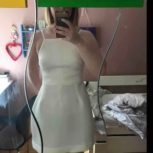  - Vit klänning i lite ”stabilare” material. Jättefin öppning i ryggen (skicka pm för bättre bild). Justerbara axelband. Perfekt till studenten/skolavslutning!  Använd en gång. Pris inklusive frakt