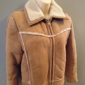  - Unik fårskinnsjacka från Levi's! Särskilt tillverkad för den amerikanska OS-truppen 1984. Jag köpte den från USA via Ebay för 3000 kr, tyvärr var den för liten för mig 😞  Kan skickas. Finns i Hägersten.     Material: Äkta fårskinn, utanpå och inuti. Helfodrad så den är riktigt varm och gosig.   Mått:  Byst 100 cm  Midja 92 cm  (Räkna bort ca 10 cm på dessa pga tjockt foder) Längd 60 cm  Ärmlängd 57, 5 cm  Skick: Förutom en lagning på vänstra ärmen (baksidan) som knappt syns (se bild) är jackan i fint bruksskick. Små slitna detaljer får man räkna med när det är vintage.     En jacka du garanterat blir ensam om!  