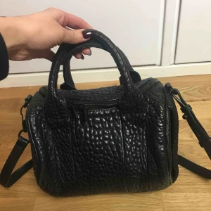  - Alexander wang väska med nitar. Väskan är självklart äkta och köpt på NK i Stockholm. Kvitto finns kvar. Nypris på väskan är 7200:-  Säljes för 2000:- då lädret slitits på vissa ställen. 