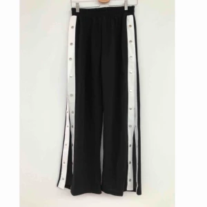  - Svarta vida byxor med vit rem och knappar längst sidan. Knapparna kan öppnas/stängas hela vägen! Använda en gång! Köparen står för frakten! 