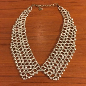  - Silvrigt halsband som ser ut som en krage. Köpt i London men har aldrig blivit använt.