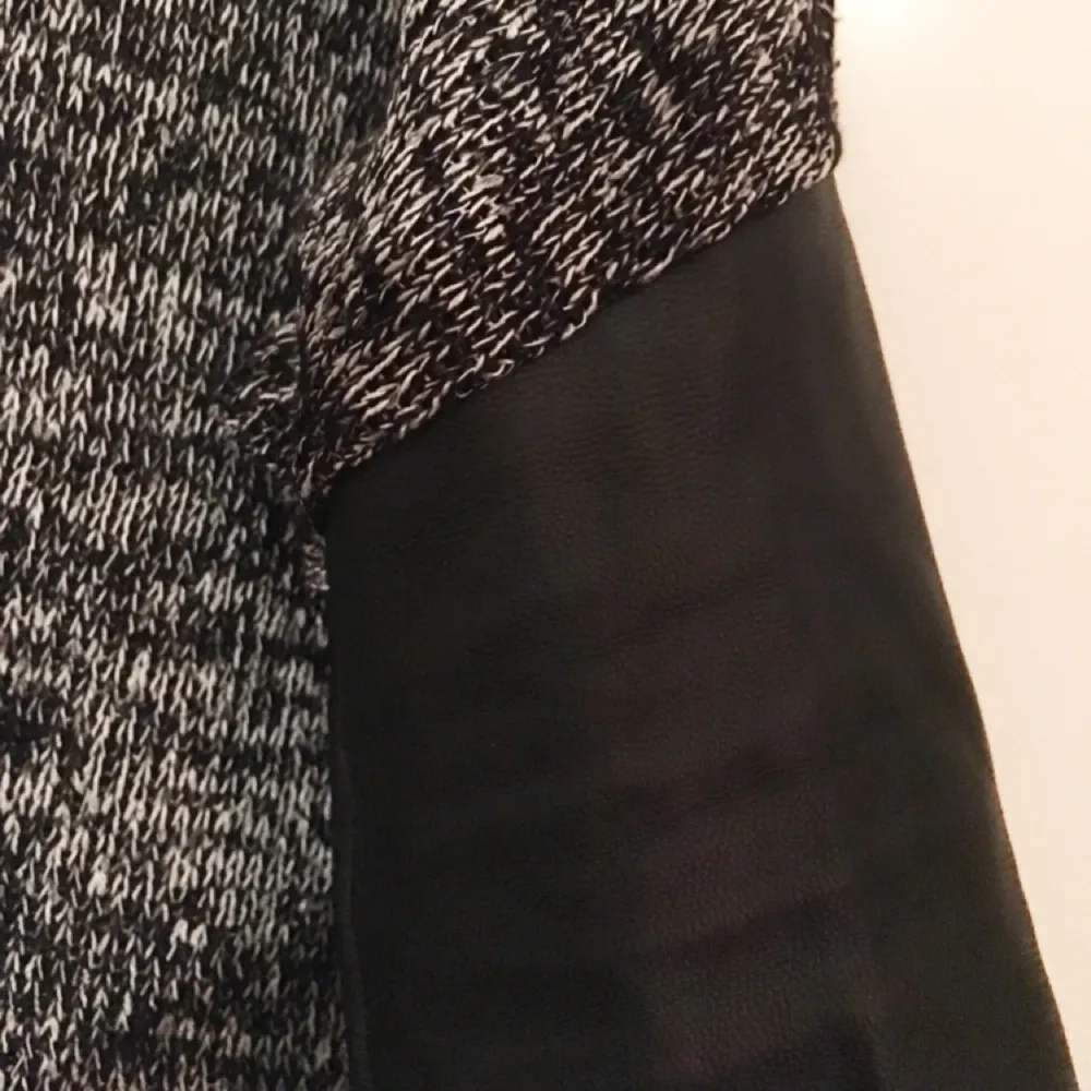 Grå/svart tunnt stickad långärmad tröja med ärmar i skinnimitation, från H&M. . Toppar.