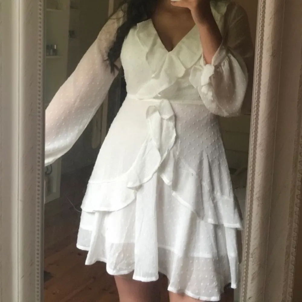Fin vit klänning med volanger och stora ärmar. Passar jättebra som studentklänning! Endast använd en gång. Klänningar.