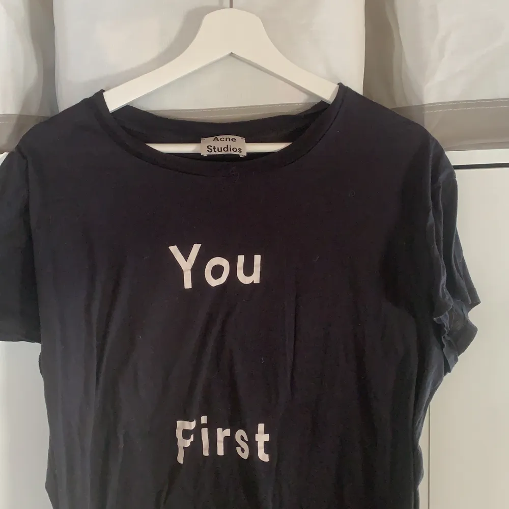 svart t shirt från acne i bra skick, populära ”you first” trycket , köparen står för frakt!. T-shirts.