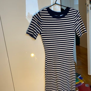 Tight, randig & ribbad t-shirtsklänning - T-shirtsklänning i ribbat material från H&M. Mörkblå & Vit. Lite noppig, men märks knappt (se sista bilden). Köpare betalar frakt!