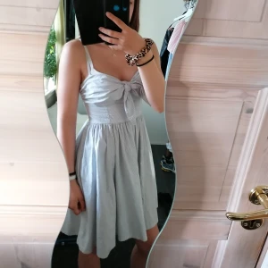 Randig sommarklänning - En jättefin sommarklänning från H&M med ljusblåa ränder och rosett där fram, det finns resår vid ryggen (syns bild 2) och banden är gysterbara 🌸 Inga hål eller fläckar🌸 storlek 34 men passar även 36 och S,(tillkommer frakt🌸)många intresserade så skriv! 😊