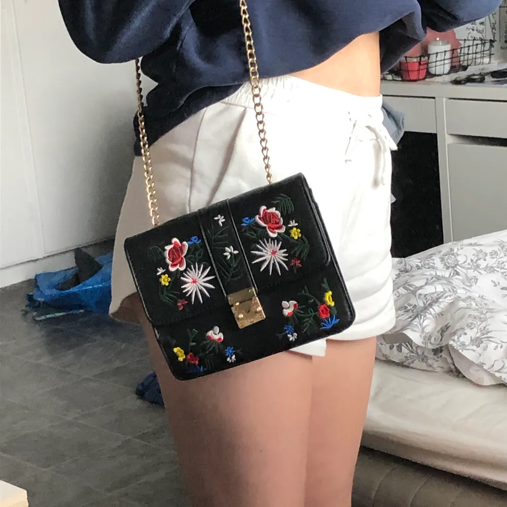 en gullig väska med broderade blommor och guldkedja:) har en liten ficka där i ock är endast använd ett fåtal gånger! passar perfekt till en mer basic outfit 🥰. Väskor.