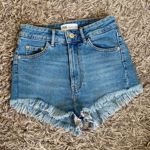 Jeans shorts från zara - Snygga jeansshorts från zara med slitningar i kanten. 