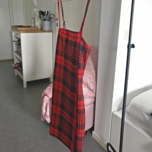 Cool rutig klänning 🔥 - Sjukt snygg tight klänning i rött och svart. Bilden ser lite mer röd/blå ut men det är svart. Den är stretchig i tyget och sitter snyggt, axelbanden går att justera. Köpt från Shein, storleken är L men passar bäst på S-M. 🔥 Frakt tillkommer på 20:- 